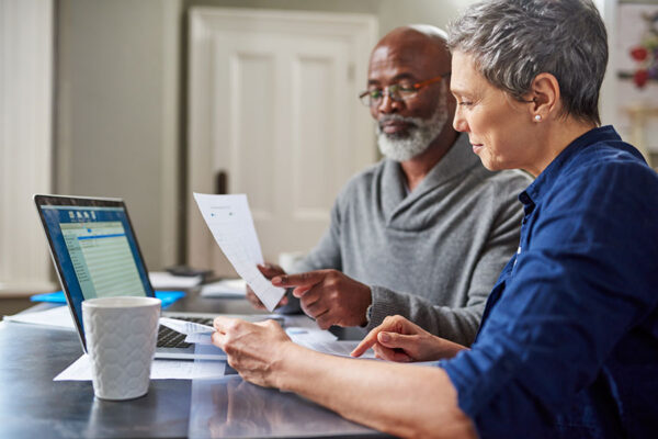 A senior couple work together to manage accounts online