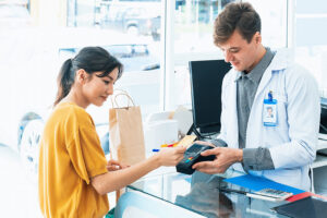 Woman taps card to make purchase at a pharmacy