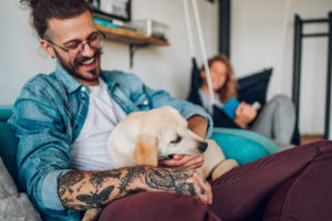 A man holds a newish puppy on his lap