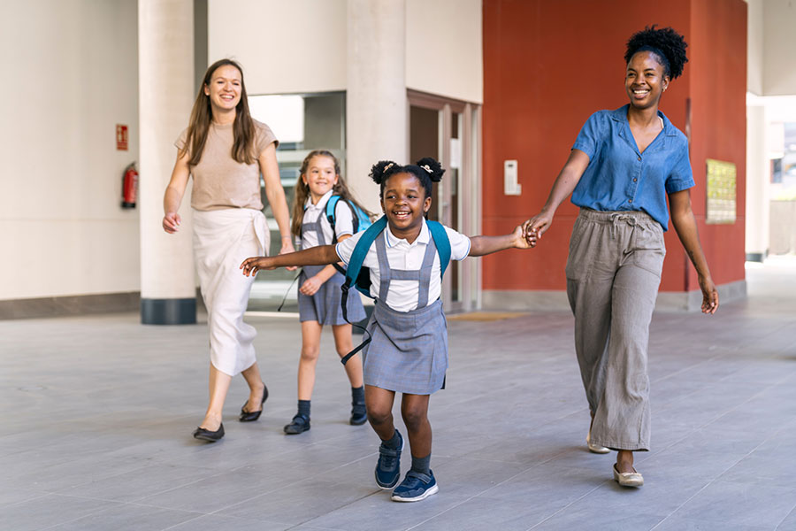 Two mothers pick their daughters up from school